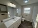 Bright bathroom with modern vanity, large mirror, and subway tile shower, showcasing a fresh, updated look at 1735 Hollandale Dr, Gastonia, NC 28054