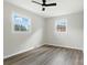 A naturally lit bedroom with two windows, a ceiling fan, and vinyl flooring at 1735 Hollandale Dr, Gastonia, NC 28054