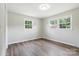 Bright bedroom featuring fresh paint, modern flooring, and dual windows at 1735 Hollandale Dr, Gastonia, NC 28054