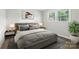 A cozy bedroom featuring a large bed, neutral tones, and natural light from the window at 1735 Hollandale Dr, Gastonia, NC 28054