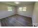 Bright bedroom featuring wood-look floors and natural light from two windows at 1735 Hollandale Dr, Gastonia, NC 28054