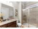 Bathroom featuring granite countertop, dark wood cabinetry, and glass-enclosed shower at 19004 Dry Narrows Way, Charlotte, NC 28278