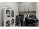 Laundry room features front loading washer and dryer and white cabinets for storage at 19004 Dry Narrows Way, Charlotte, NC 28278