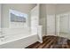 Bright bathroom featuring a soaking tub, wood-look flooring, and a window view at 2028 Covered Bridge Ct, Rock Hill, SC 29732