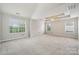 Spacious main bedroom with tray ceilings, a ceiling fan, large windows, and neutral carpet at 2028 Covered Bridge Ct, Rock Hill, SC 29732