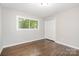 Bedroom featuring hardwood floors, a closet, and two windows at 205 E Cleveland Ave, Bessemer City, NC 28016