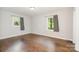 Bright bedroom featuring hardwood floors, two windows with patterned curtains and neutral walls at 205 E Cleveland Ave, Bessemer City, NC 28016