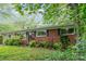 Charming home with brick and vinyl siding, surrounded by mature trees and landscaping at 205 E Cleveland Ave, Bessemer City, NC 28016