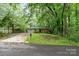 Quaint one-story home with a brick facade and a lawn, set among mature trees at 205 E Cleveland Ave, Bessemer City, NC 28016