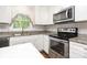 Well-lit kitchen featuring stainless steel appliances and neutral-colored countertop and cabinets at 205 E Cleveland Ave, Bessemer City, NC 28016