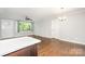 Open living room with hardwood floors, large window, ceiling fan, and modern light fixture at 205 E Cleveland Ave, Bessemer City, NC 28016
