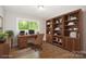 Home office with lots of built in storage, wood floors, a desk and large window at 205 E Cleveland Ave, Bessemer City, NC 28016