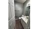 A cozy bathroom is equipped with a white toilet, white cabinets, and wooden-look flooring at 2106 S Main St, Kannapolis, NC 28081