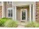 Inviting front porch with white columns, manicured greenery, and a decorative welcome mat at 228 Dawn Mist Ln, Fort Mill, SC 29708