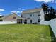 Spacious backyard with a white fence, lush green grass, and a glimpse of the home's exterior at 2311 Verde Creek Rd, Charlotte, NC 28214