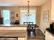 Dining area with modern lighting adjacent to the kitchen with granite countertops and white tile backsplash at 2311 Verde Creek Rd, Charlotte, NC 28214