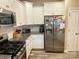 Well-lit kitchen with stainless steel appliances, white cabinets, granite countertops, and tile backsplash at 2311 Verde Creek Rd, Charlotte, NC 28214