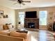 Cozy living room with stone fireplace, modern ceiling fan, plush sofa, and natural light at 2311 Verde Creek Rd, Charlotte, NC 28214