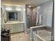Bright main bathroom with double vanity, tub, and glass shower enclosure at 2311 Verde Creek Rd, Charlotte, NC 28214