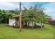 Small home with a covered back porch, green yard, and a large tree providing shade at 3 Circle Dr, Lincolnton, NC 28092