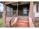 Rustic porch with brick columns, wood railings, painted steps, and an inviting entry door at 3 Circle Dr, Lincolnton, NC 28092
