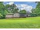 Back exterior of a house featuring a screened porch, patio and grassy backyard in a wooded setting at 3017 Brooks Mill Ln # 10, Wingate, NC 28174