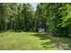 Spacious backyard with a shed, trampoline and ample space for outdoor activities surrounded by tall trees at 319 S San Agustin Dr, Mooresville, NC 28117