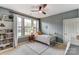 Well-lit bedroom with a cozy bed, large windows, and a charming bookshelf at 319 S San Agustin Dr, Mooresville, NC 28117