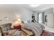 Comfortable bedroom with a striped comforter, reading chair, and neutral walls with window at 319 S San Agustin Dr, Mooresville, NC 28117