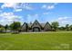 Exterior view of the clubhouse with green space, blue sky and ample parking at 319 S San Agustin Dr, Mooresville, NC 28117