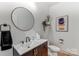Stylish half bathroom with a round mirror, modern vanity, and elegant wall art at 319 S San Agustin Dr, Mooresville, NC 28117