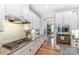Charming kitchen featuring white cabinets, granite countertops, stainless steel appliances, and hardwood flooring at 319 S San Agustin Dr, Mooresville, NC 28117