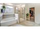 Spa-like main bathroom with soaking tub, glass-enclosed shower, and walk-in closet access at 319 S San Agustin Dr, Mooresville, NC 28117