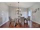 Inviting dining area featuring a glass-top table, modern chandelier, and hardwood flooring, perfect for gatherings at 3342 Yarmouth Ln, Gastonia, NC 28056