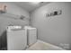Functional laundry room with a washer, dryer, and shelving for storage at 3342 Yarmouth Ln, Gastonia, NC 28056