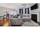 Open-concept living room with a gray sectional sofa, fireplace, and a view of the dining area at 3342 Yarmouth Ln, Gastonia, NC 28056