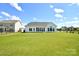 A large backyard with ample green space complements the modern white home at 3924 Dahlia Dr, Harrisburg, NC 28075