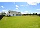 Expansive backyard featuring a lush green lawn and a modern white home exterior at 3924 Dahlia Dr, Harrisburg, NC 28075