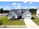 Charming home with stone accents, a manicured lawn, and a paved driveway at 3924 Dahlia Dr, Harrisburg, NC 28075
