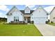 Charming single-story home featuring a manicured lawn, stone accents, and an attached two-car garage at 3924 Dahlia Dr, Harrisburg, NC 28075