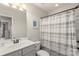 This bathroom features a shower with a striped curtain, light walls, and a modern vanity at 4278 Park South Station Blvd, Charlotte, NC 28210