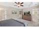 Spacious bedroom with neutral carpet, ceiling fan, ensuite bathroom access, and TV at 4278 Park South Station Blvd, Charlotte, NC 28210