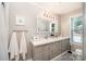 Bright bathroom featuring a double sink vanity, framed mirror, and a window providing natural light at 4586 Doctor Dr, Catawba, NC 28609