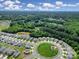 Scenic aerial view of a residential community with a green space, complemented by a lake and surrounding woods at 461 Misty Law Ln, Clover, SC 29710