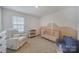 Warm Bedroom featuring a crib, mountain art, rocking chair, natural light, and neutral carpet at 461 Misty Law Ln, Clover, SC 29710