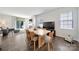 Bright dining area features hardwood floors, a large table, and seamless connection to the living room at 461 Misty Law Ln, Clover, SC 29710