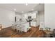 Open kitchen with a granite island, white cabinetry, stainless appliances, and hardwood floors at 461 Misty Law Ln, Clover, SC 29710