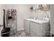 Practical laundry room with washer, dryer, storage shelving, and tiled floors at 461 Misty Law Ln, Clover, SC 29710