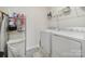 Spacious laundry room equipped with a washer, dryer, shelving, and gray tiled floors at 461 Misty Law Ln, Clover, SC 29710