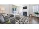Bright living room includes a fireplace, modern patterned rug, neutral gray sofa, and sliding glass doors to the patio at 461 Misty Law Ln, Clover, SC 29710